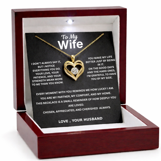 Gold heart-shaped necklace with a message card in a wooden box